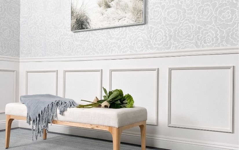 Chair rail with wallpaper above and white wall moulding below in a finished entryway