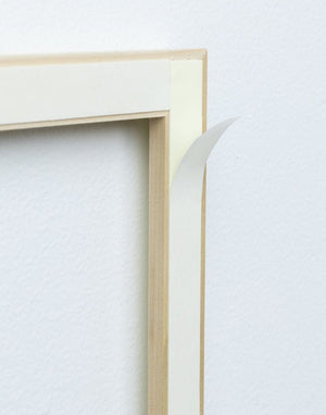 Close up picture of back of real wood moulding frame showing adhesive for easy application for self-adhering wall moulding and wainscotting stain grade