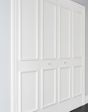 Side view of removable four piece bi-fold door moulding kit on white closet doors