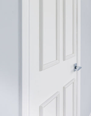 Side view of removable four piece door moulding kit on white interior doors